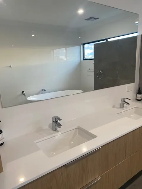 Bright bathroom with a clean white vanity and mirror
