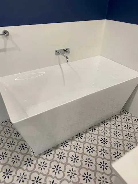 Freestanding bath and patterned floor tiles after a bathroom clean
