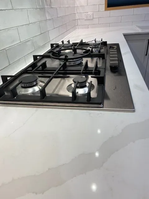 Gas cooktop and stone benchtop after a kitchen clean