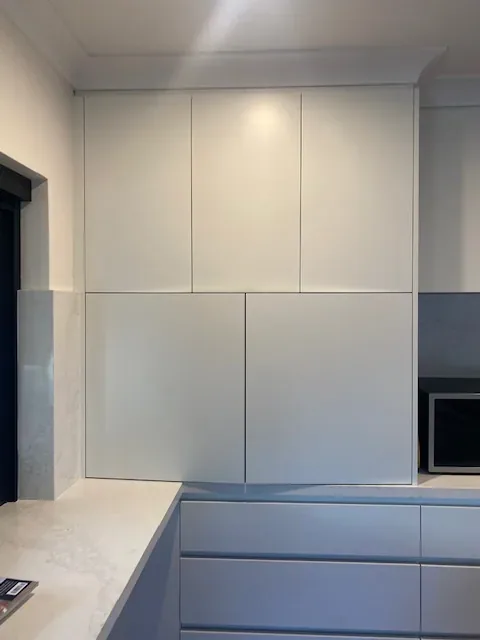 White kitchen cabinets and benchtop after cleaning
