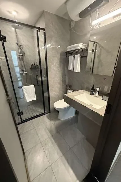 Ensuite with a glass shower, vanity and tiled floor after a clean