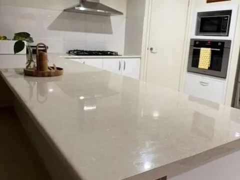 Stone kitchen island, rangehood and wall oven after a deep clean