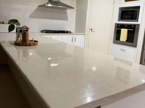 Stone kitchen island, rangehood and wall oven after a deep clean