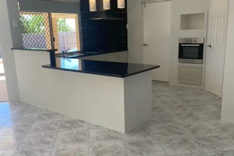 Kitchen island and wall oven in a Perth home after a residential clean